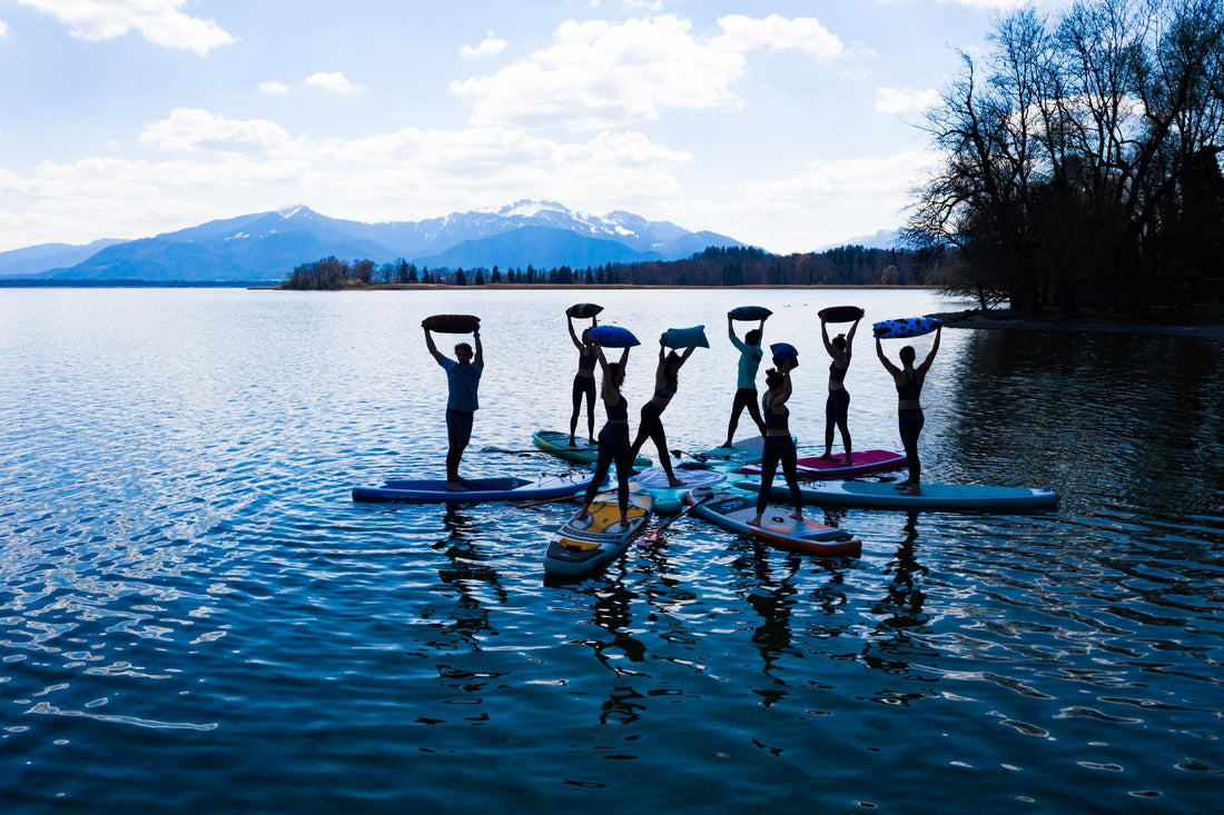 SUP-Yoga auf dem Chiemsee — Gruppe auf Stand-up-Paddle-Boards vor den Alpen